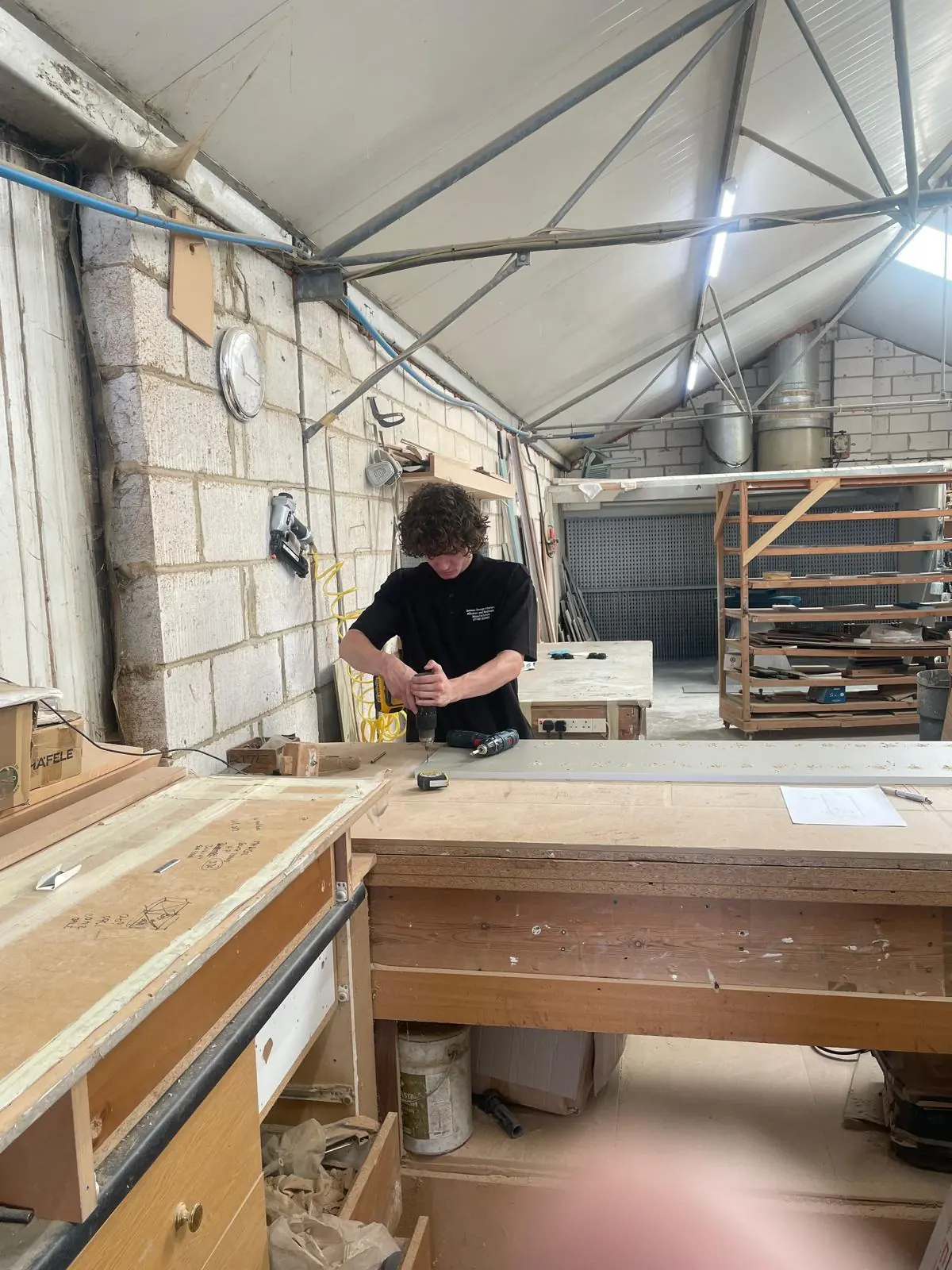 One of Paul's sons assembling a cabinet at the workshop bench
